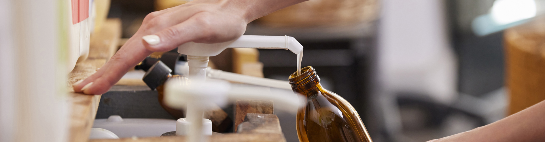 Someone refilling refillable bottle with pump of product